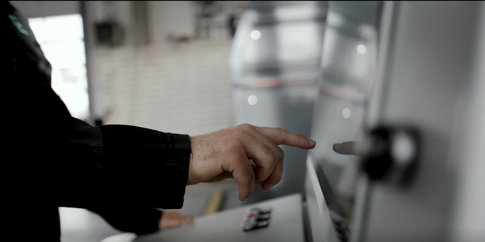 Bild, das einen Finger zeigt, der auf ein Bedienpanel zeigt und dort etwas zum Anklicken auswählt